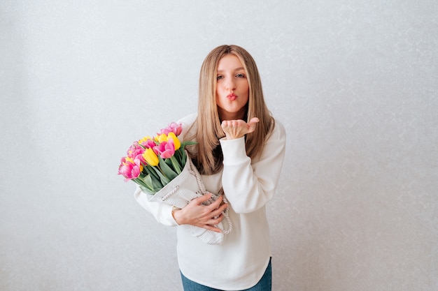 Air kissing woman holding tulips