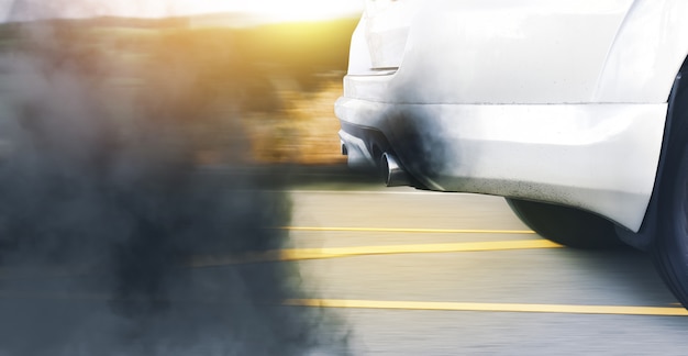 Загрязнение воздуха от автомобиля с устаревшим дизельным двигателем и черный дым на дороге