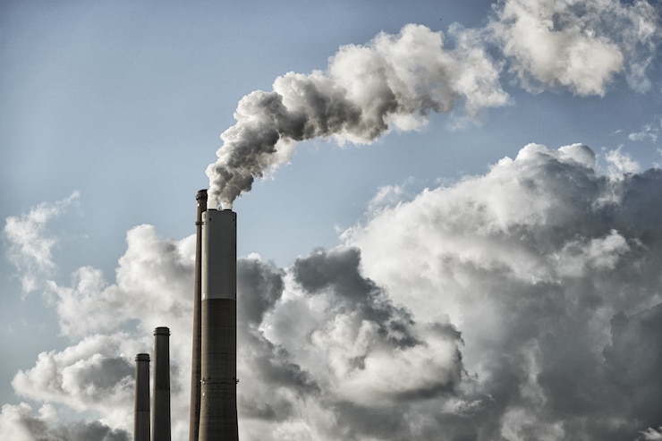 Photo air pollution. long pipes of a factory, plant or powerhouseare smoking and polluting the air and atmosphere.