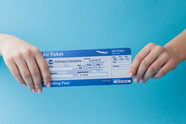 Air ticket in woman hand on a pink