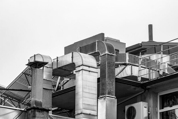 Air ventilation flow system on the roof of the building vent pipe fan hvac black and white