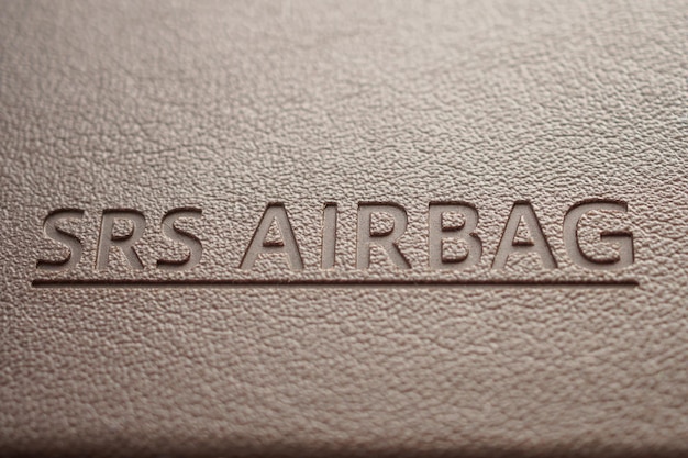 Photo airbag safety sign on brown leather texture in modern car