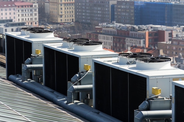 Airco ventilatoren op dak met huizen op de achtergrond