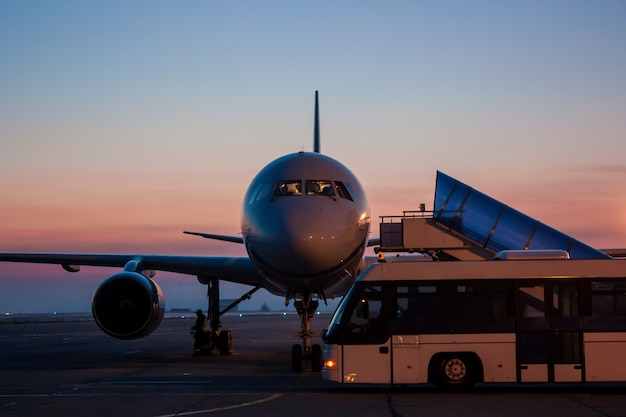 Aircraft and bus on the early morning airport apron