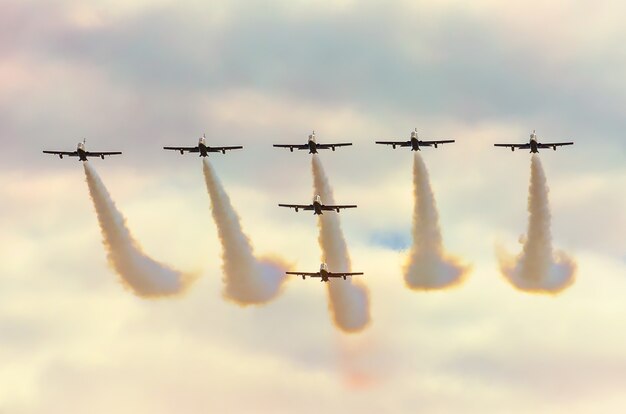 Gli aerei da combattimento fumano sullo sfondo delle nuvole del cielo.