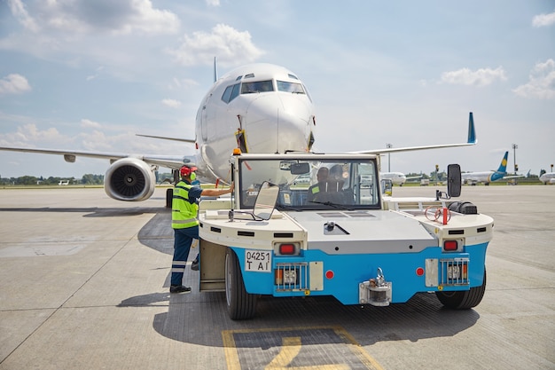 Aircraft maintenance supervisor and an experienced vehicle operator looking at the airplane landed on the runway