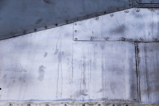 Aircraft skin close up. Rivets on gray metal. Aluminum texture