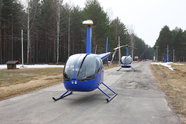 航空機森の背景に2機の青いヘリコプター