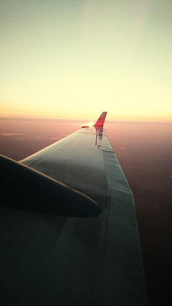 写真 夕暮れの晴れた空を背景に飛行機の翼