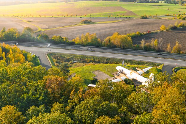 森の近くの野原の旅客機。落葉樹に囲まれた高速道路近くの飛行機のレストラン。ムラダボレスラフ、