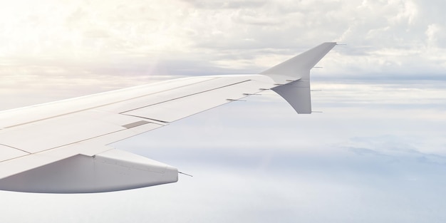 Airplain wing view thrue window in the sky clouds sky airplanes wing through porthole of aircraft