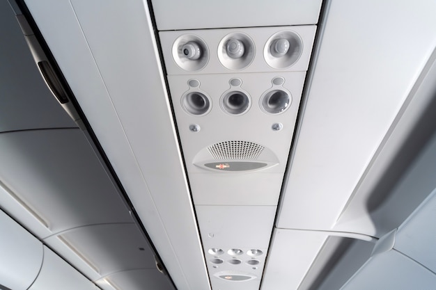 Foto pannello di controllo del climatizzatore dell'aeroplano sopra i sedili. aria soffocante nella cabina dell'aeromobile con persone. nuova compagnia aerea a basso costo
