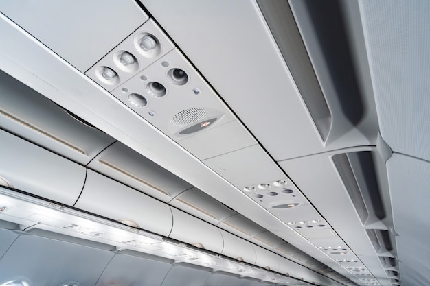 Airplane air conditioning control panel over seats. Stuffy air in aircraft cabin with people. New low-cost airline