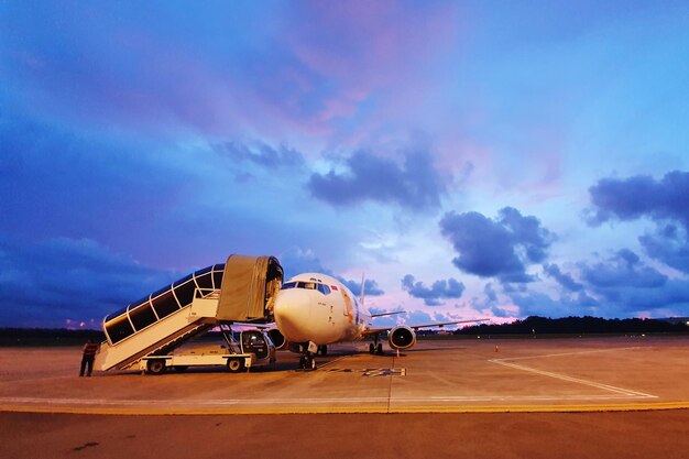 Airplane on airport runway against sky