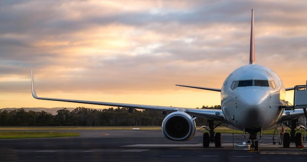 Самолет на взлетно-посадочной полосы аэропорта на закате в Тасмании