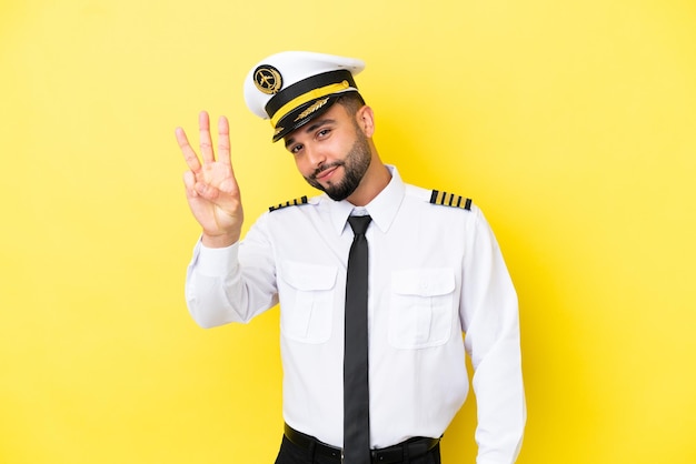 Airplane arab pilot man isolated on yellow background happy and counting three with fingers