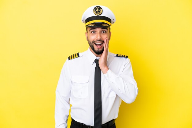 Airplane arab pilot man isolated on yellow background with surprise and shocked facial expression