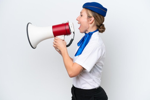 Airplane blonde stewardess woman isolated on white background shouting through a megaphone