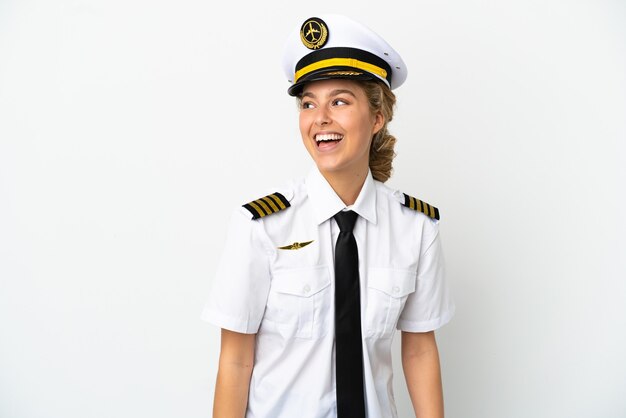 Airplane blonde woman pilot isolated on white background looking to the side and smiling