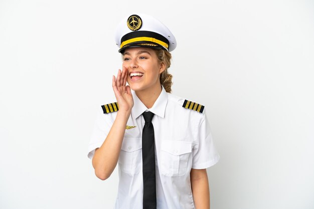 Airplane blonde woman pilot isolated on white background shouting with mouth wide open to the side