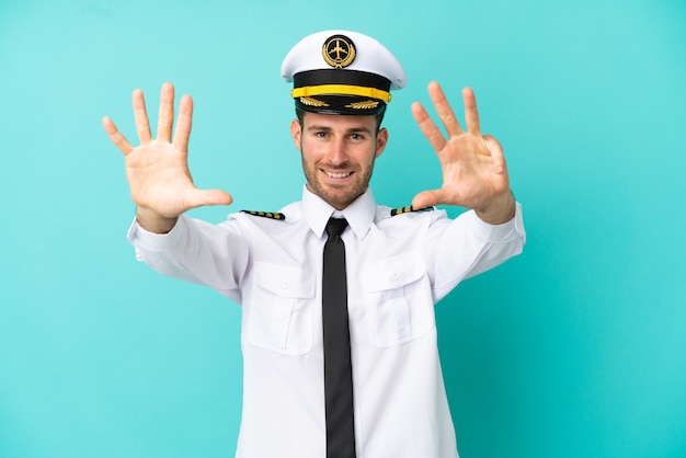 Airplane caucasian pilot isolated on blue background counting nine with fingers