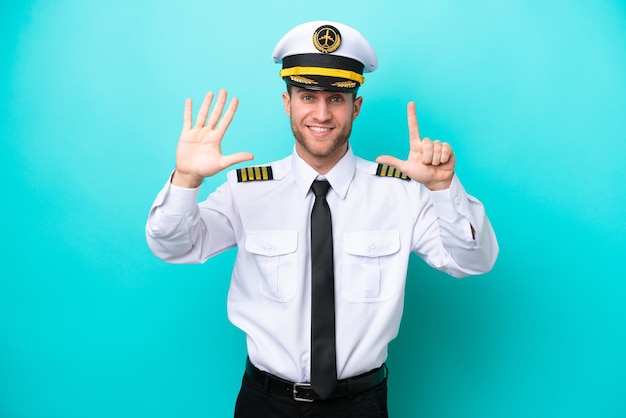 Airplane caucasian pilot isolated on blue background counting seven with fingers