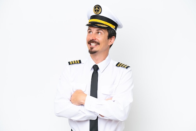 airplane caucasian pilot isolated on white background looking up while smiling