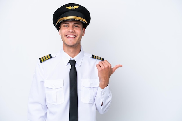 Airplane caucasian pilot isolated on white background pointing to the side to present a product