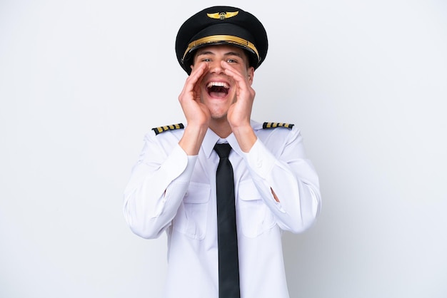 Airplane caucasian pilot isolated on white background shouting and announcing something