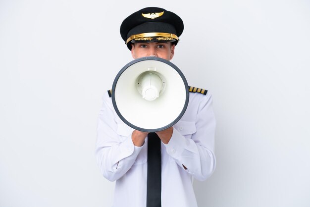 Airplane caucasian pilot isolated on white background shouting through a megaphone