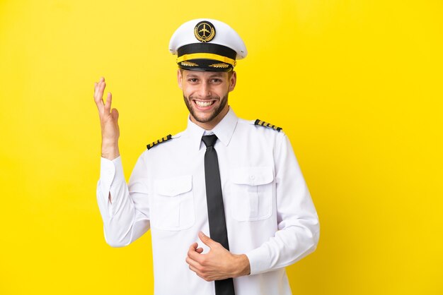 Airplane caucasian pilot isolated on yellow background making guitar gesture