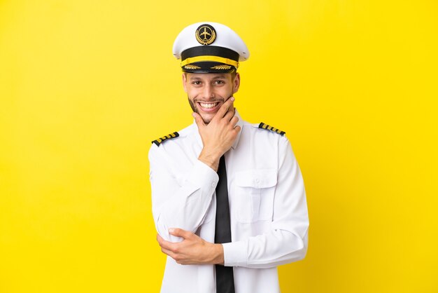 Airplane caucasian pilot isolated on yellow background smiling