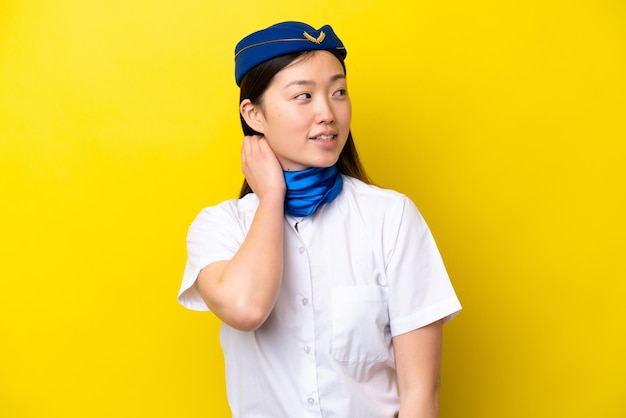 Airplane Chinese woman stewardess isolated on yellow background thinking an idea