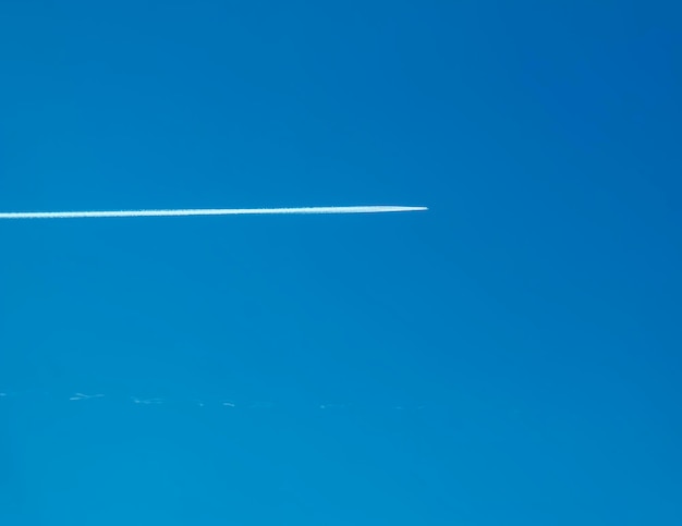 Foto traccia di condensazione dell'aereo e aereo sul cielo blu