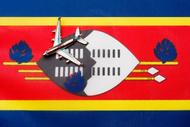 Photo airplane over flag of swaziland travel and tourism concept