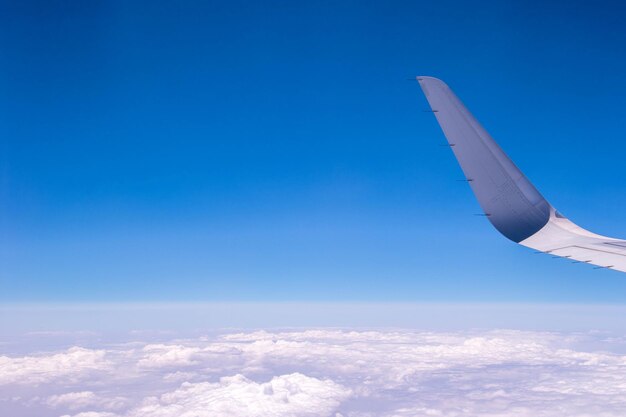 Airplane flying over clouds against blue sky