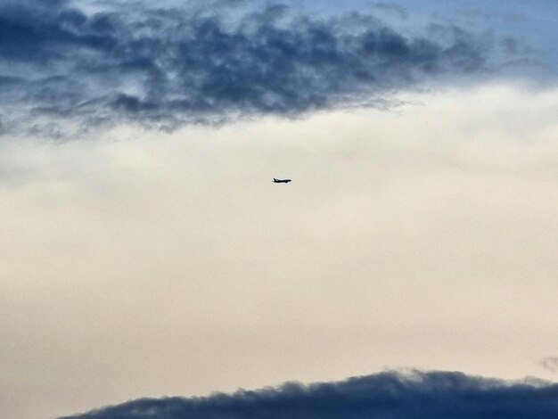 Photo airplane flying over the clouds in the sky backgrounds