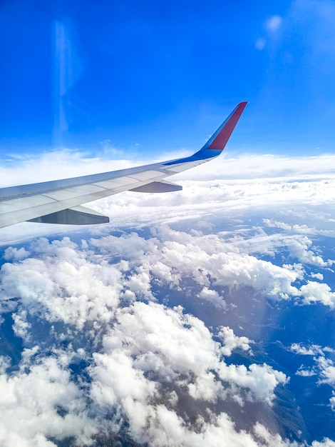 空の雲の翼の上を飛んでいる飛行機