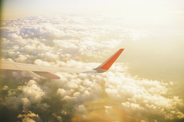 空の向こうの雲の上を飛ぶ飛行機