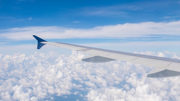 空に向かって雲の上を飛ぶ飛行機