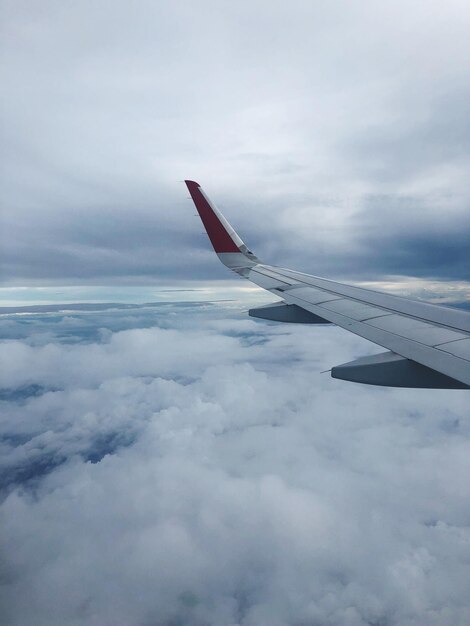 Aereo che vola sopra il paesaggio nuvoloso contro il cielo