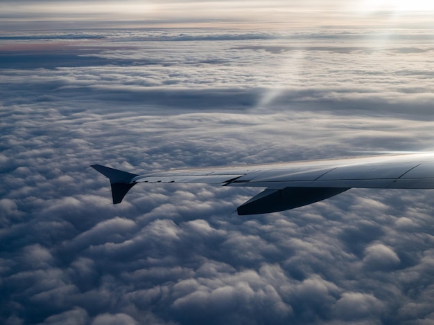 空の向こうの雲の上を飛ぶ飛行機