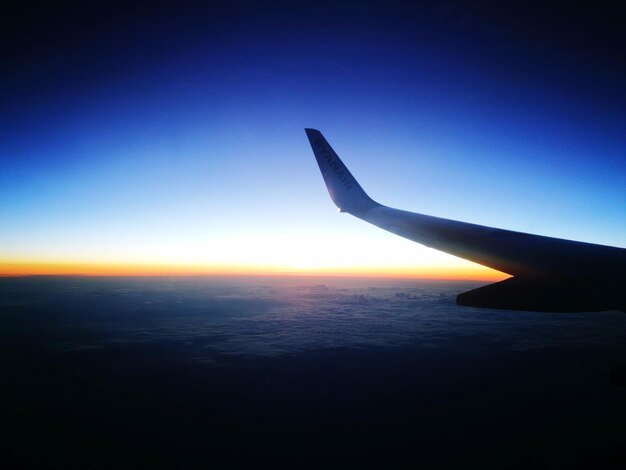 写真 夕暮れの空を飛ぶ飛行機