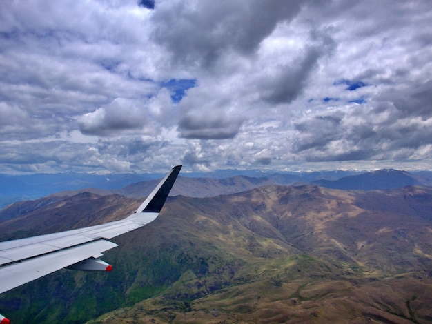 Airplane flying over mountains against sky