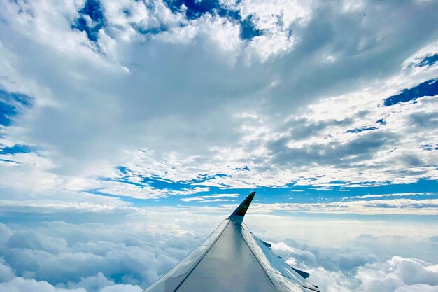 写真 空に向かって雲の上を飛ぶ飛行機