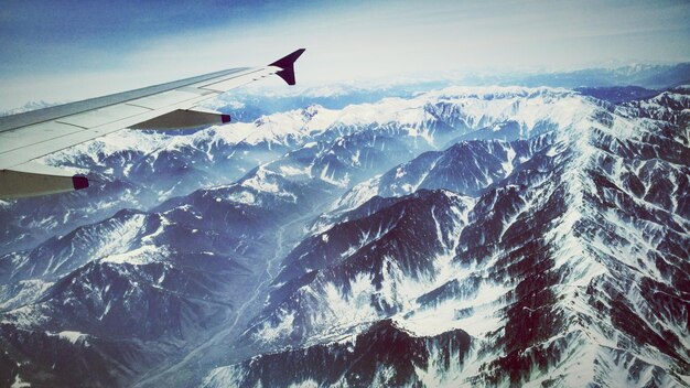 写真 空に向かって山を飛ぶ飛行機