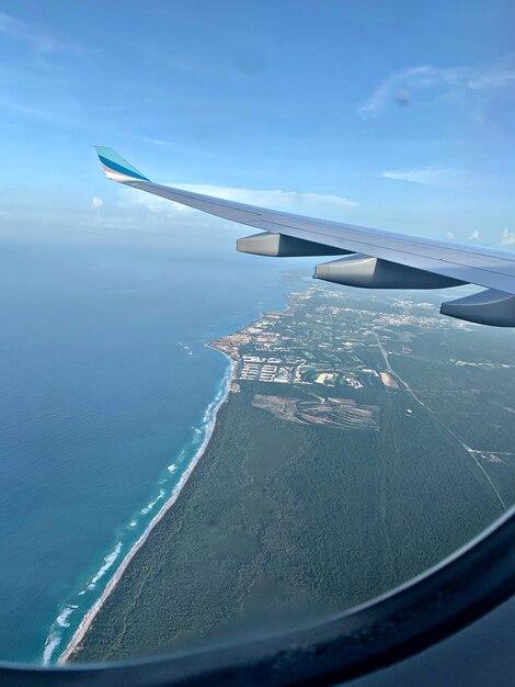 Airplane flying over sea against blue sky