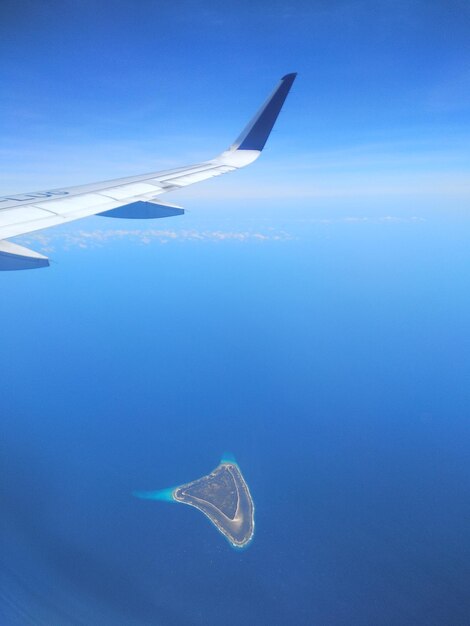 Foto aereo che vola sopra il mare contro il cielo blu