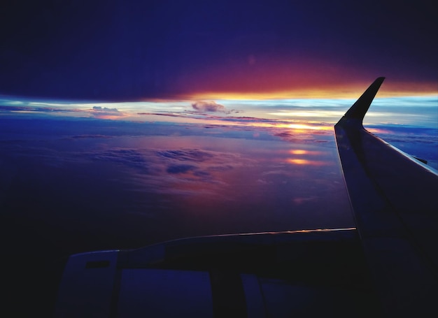 Photo airplane flying over sea against sky during sunset