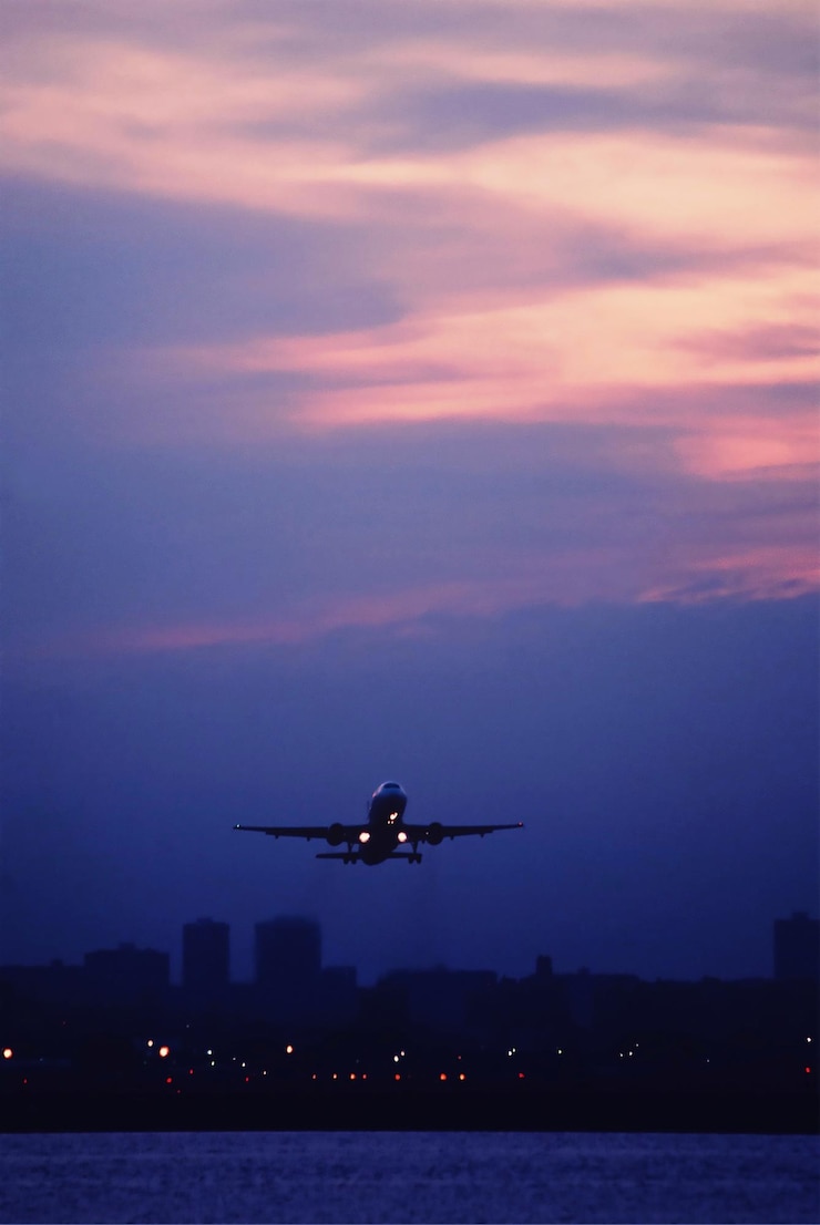 Photo airplane flying over sea against sky during sunset